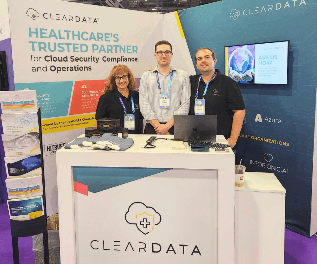 ClearDATA team at HLTH 2025 discussing cloud security for healthcare and compliance solutions, with booth signage highlighting multi-cloud and HIPAA-compliant managed services.